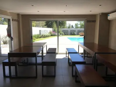 a restaurant with tables and benches and a pool at Departamento amplio y muy iluminado en 9 piso, con piscina in Río Cuarto