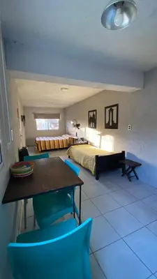 a bedroom with a bed and a table and chairs at Monoambiente calamuchita in Santa Rosa de Calamuchita