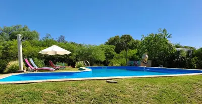 a swimming pool in a yard with an umbrella at Vayu- en La Casa de Nanda in San Javier