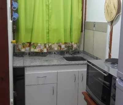 a kitchen with a sink and a green curtain at VASOS Y BESOS - Cabaña 1 in Villa Parque Siquiman