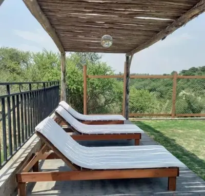 two benches on a deck with a wooden roof at VASOS Y BESOS - Cabaña 1 in Villa Parque Siquiman