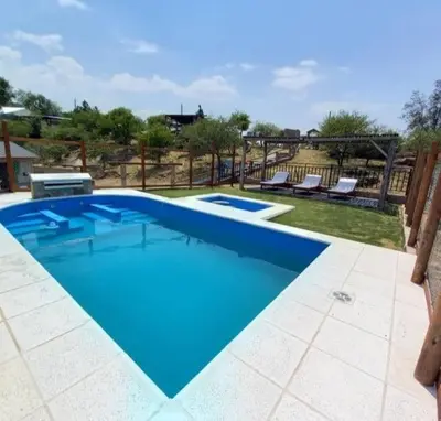 a large blue swimming pool with two lounges at Cabaña 2 in Cordoba