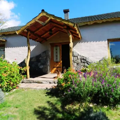 a house with a wooden door and a stone wall at La Calandria in Los Hornillos
