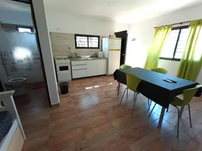 a kitchen and dining room with a table and chairs at Complejo Barranca Poceña in Quebrada de los Pozos