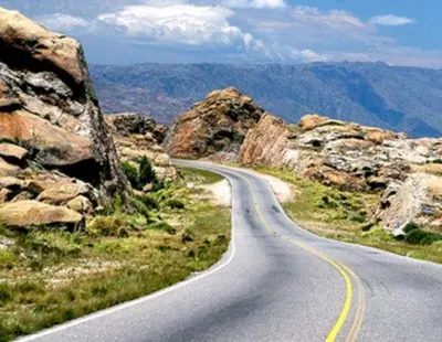 a winding road in the mountains with rocks at Mis Aromos in Mina Clavero