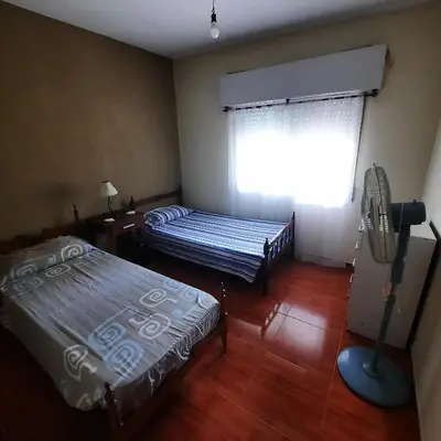 a room with two beds and a window with a fan at El sueño de papá in Santa María