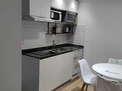 a small kitchen with a sink and a microwave at Villa Carlos Paz departamento con pileta in Villa Carlos Paz