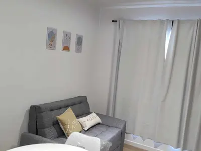 a living room with a gray couch and a window at Dpto en Carlos Paz con vista al Lago in Villa Carlos Paz