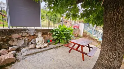 a picnic table and a statue next to a tree at LUSANYUN 1 in Villa Independencia