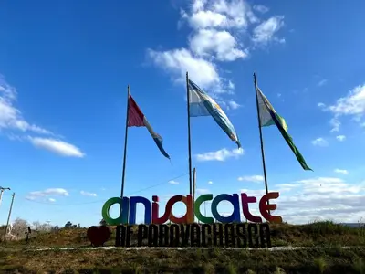 a sign with three flags in a field at EcoCasa in Cordoba