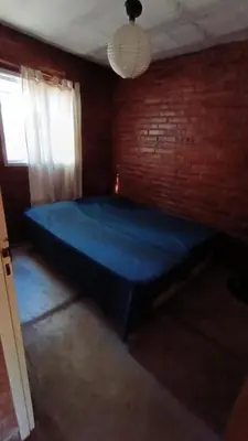 a blue bed in a room with a brick wall at Al pie del cerro in San Javier