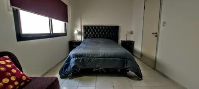 a bedroom with a bed and a window and a chair at Oasis, departamento en Carlos paz in Villa Carlos Paz
