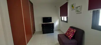 a living room with a chair and a television at Oasis, departamento en Carlos paz in Villa Carlos Paz