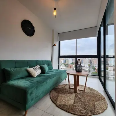 a living room with a green couch and a table at Loft en Güemes Piso 9 in Cordoba