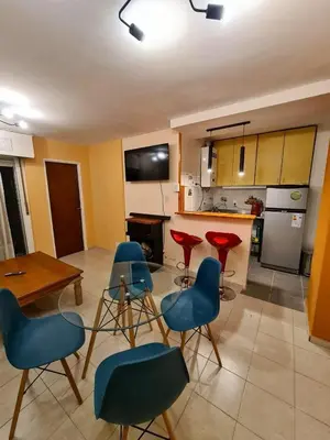 a kitchen with blue chairs and a table and a counter at Exclusivo Departamento en Nva Cba!!! in Cordoba
