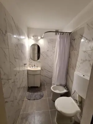 a white bathroom with a toilet and a sink at Exclusivo Departamento en Nva Cba!!! in Cordoba