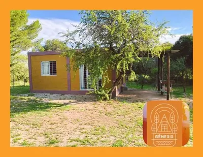 a small yellow house with a box in front of it at Genesis Paz y Montaña Mallin Tanti in Tanti