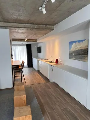 a kitchen with white cabinets and a table and a dining room at De lo mejor en Barrio General Paz in Cordoba