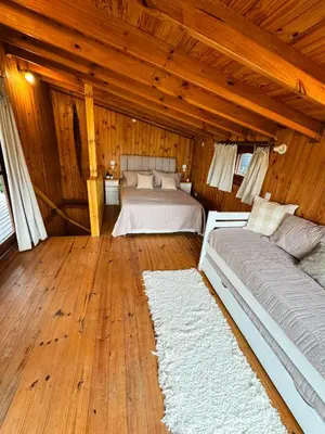 a bedroom with two beds and a wooden ceiling at Casa Mona in Potrero de Garay