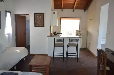 a kitchen with two chairs and a counter in a room at Depto Granja de Funes in Cordoba