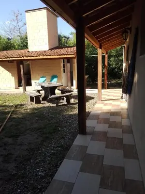 an outdoor patio with a picnic table and chairs at Dormis Clave de Sol in Villa Ciudad Parque