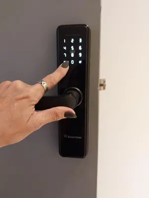 a person holding a remote control on a door at Departamento 611 - Edificio VILAUT by INMOVE Temporarios in Cordoba