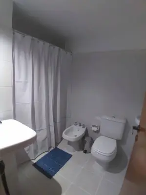 a white bathroom with a toilet and a sink at Gran Ubicacion Nueva Cordoba in Cordoba