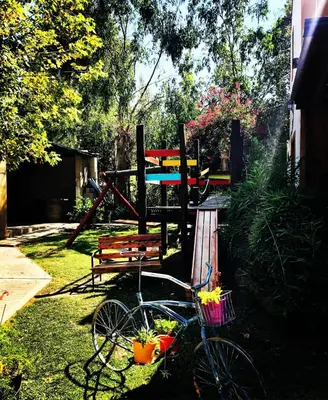 a bike parked in the grass next to a bench at cabañas el viejo ciprés 3 in Santa Rosa de Calamuchita