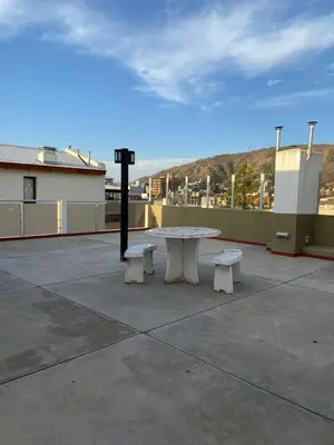 a picnic table and two benches on a patio at Departamento Edificio Manantiales in Villa Carlos Paz