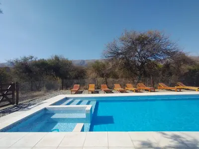 a swimming pool with lounge chairs at Cabañas Mi Respiro in Los Molles