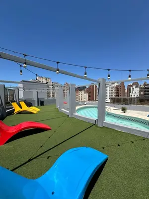 a rooftop patio with a pool and green grass at Departamento amoblado 1 dorm con amenities 516 INVERHOME INMOBILIARIA in Cordoba