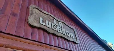 a sign on the side of a red building at Cabaña LA LUGARDA in Cuesta Blanca