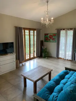 a living room with a blue couch and a table at Hermosa casa de veraneo con pileta in Villa Carlos Paz