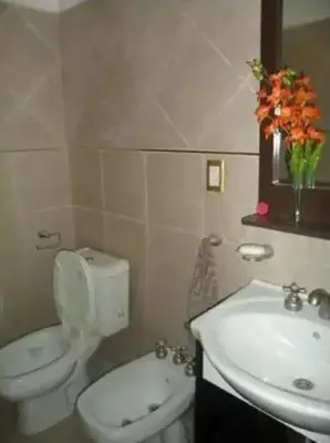 a bathroom with a white toilet and a sink at Complejo Luluara in Villa Carlos Paz