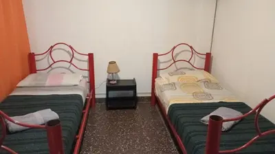 two twin beds in a small room with a lamp at Complejo Luluara in Villa Carlos Paz