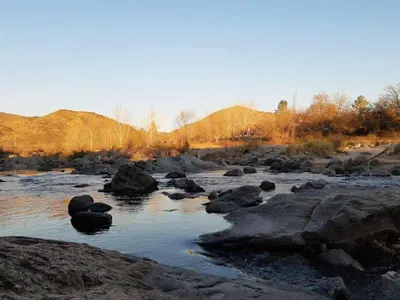 a river with some rocks and some water at Complejo Luluara in Villa Carlos Paz