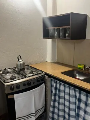 a stove in a kitchen with a tea kettle on it at Habitaciones Monarcas in Villa Carlos Paz