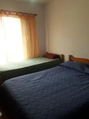 two beds in a room with a window at Lo de Andres in Santa María