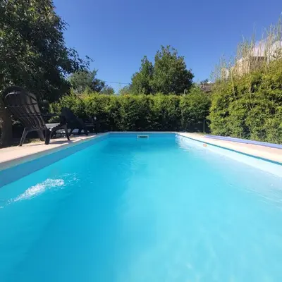 a large blue swimming pool with two chairs in a yard at Casa Moraa in Nono