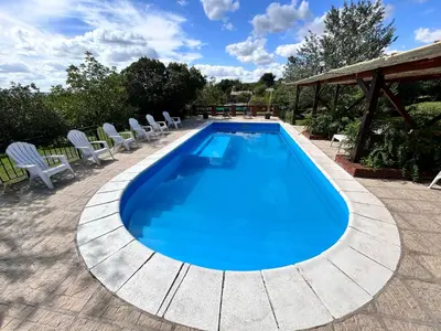 a swimming pool with lounge chairs around it at Cabaña Alamo in Mina Clavero