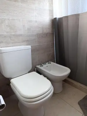 a bathroom with a white toilet and a sink at Yatel in Santa Rosa de Calamuchita