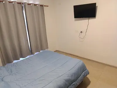 a bedroom with a bed and a flat screen tv at Yatel in Santa Rosa de Calamuchita