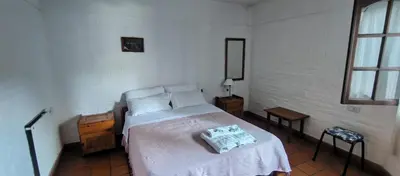 a bedroom with a bed in a white room at Residencial El Amancer in Mina Clavero