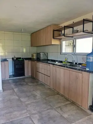 a large kitchen with wooden cabinets and a sink at La Cautivadora Potrero de Garay in Potrero de Garay