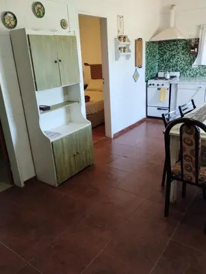 a kitchen with a refrigerator and a table and chairs at Cabaña Villa del Dique, Calamuchita in Villa del Dique