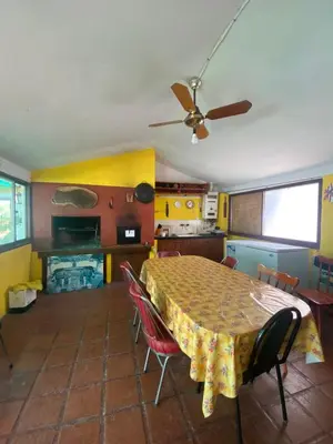a kitchen with a table with chairs and a ceiling fan at Cabaña AGU en Cabañas María in Villa Carlos Paz