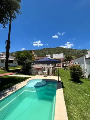 a swimming pool in a yard with a house at Cabaña AGU en Cabañas María in Villa Carlos Paz