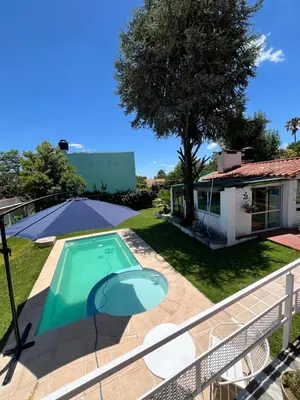 a villa with a swimming pool and a house at Cabaña EMI en Cabañas María in Villa Carlos Paz