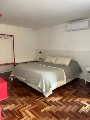 a bedroom with a bed and a wooden floor at Departamento Red - Piso 2 Laprida Once in Cordoba