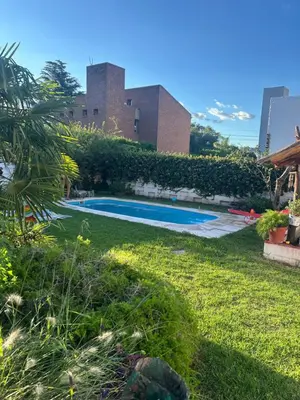 a swimming pool in the yard of a building at Casa Jazmín in Villa Carlos Paz